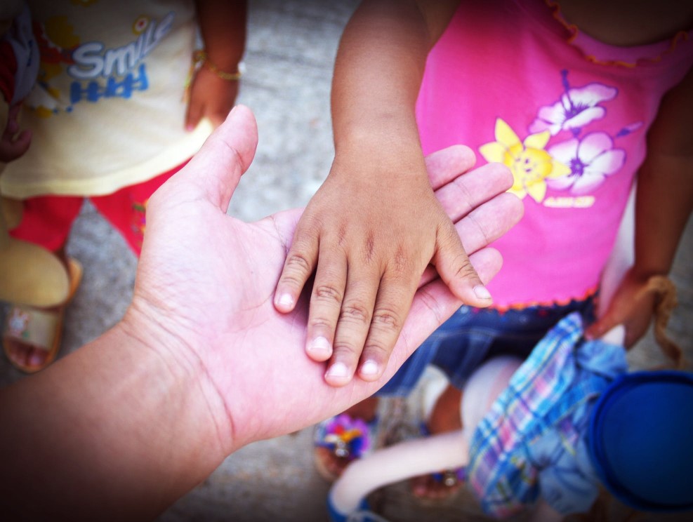 A child's hand in a person's hand